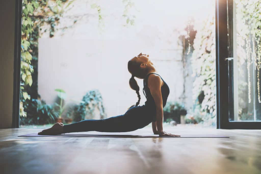Endocannabinoid system woman reaching balance doing yoga